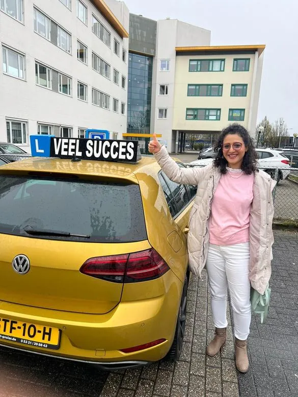 Geslaagde leerling bij de lesauto